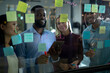 © Wavebreak Media - Diverse male and female business colleagues reading colourful memo notes on glass wall