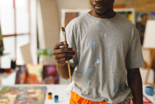 African American Male Painter At Work Holding Brush In Art Studio