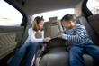 © didesign - Young brother and sister can’t make a deal about who gets the digital tablet on the backseat of the car
