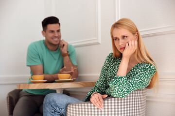 Poster - Displeased young woman and happy man during first date in cafe