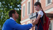 © TommyStockProject - Side view of father cheering upset daughter outside school building