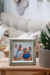 Canvas Print - Framed family photo on wooden table in living room