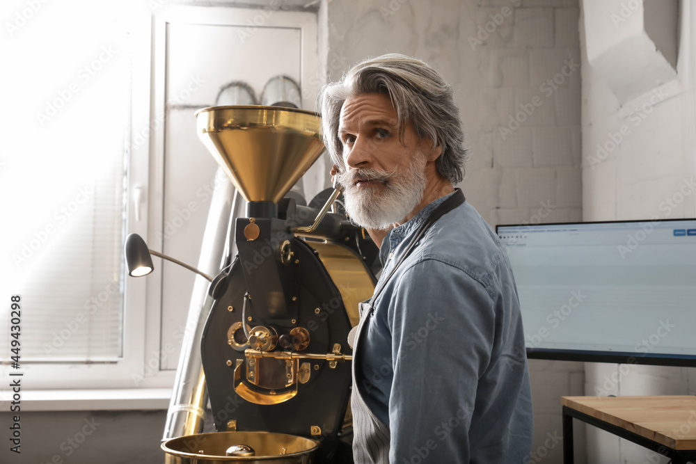 Senior man using modern coffee roaster