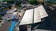 Aerial view Solar panels on a roof on hotel with view of a pool and a canal. Aerial drone view of luxury apartments with solar panels on the roof, pool.