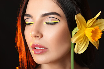 Canvas Print - Beautiful young woman with stylish makeup and flower on dark background