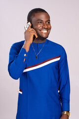 Wall Mural - happy young black man smiling while making a phone call