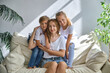 © Inna Vlasova - boy and girl hug their mom while sitting on the sofa