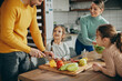 © Drazen - Young happy family prepares healthy food in the kitchen.