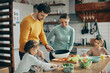 © Drazen - Young family prepares healthy food for lunch in the kitchen.