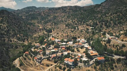 Wall Mural - Aerial view, mountain range, village panorama in highlands. Green trees and bushes on rocks. Beautiful blue sky with clouds. Travel destination. Outdoor tourism. Amazing nature landscape. Drone flight