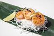 Scallop sashimi on white background. Traditional Japanese food. Seared scallop served with decor, daikon and lime on bamboo leaf. Mollusk or shellfish dish. Sushi restaurant menu. Copy space, close up