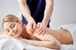 © alfa27 - Cropped Confident Nice Male Masseur Therapist In Cosmetology Room Doing Massage To Female On Back, Shirtless Lady Lying On Bed Enjoying Spa Treatment By Professional, Closing Eyes. Side View Portrait