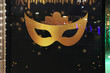Golden carnival mask painted on a New Year's black background with stars