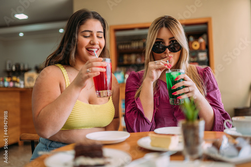 Young Latin plus size girls sitting in cafe listening funny life story of their friend