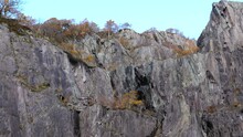 Panning Shot Of Steep Rock Walls In Disused Slate Quarry In Autumn.