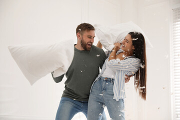 Sticker - Happy young couple having fun pillow fight at home