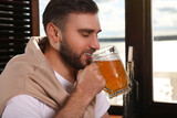 Fototapeta Mapy - Young man drinking tasty beer in pub