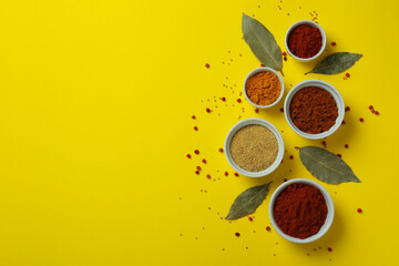 Sticker - Different spices in white bowls on yellow background