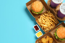 Flat Lay Composition With Delicious Fast Food Menu On Light Blue Background. Space For Text