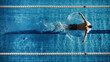 Aerial Top View Male Swimmer Swimming in Swimming Pool. Professional Determined Athlete Training for the Championship, using Butterfly Technique. Top View Shot