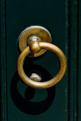 Sticker - Vertical shot of a golden knock ring on the dark green vintage door