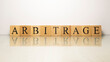 The name arbitrage was created from wooden letter cubes. finance and economy.