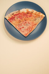 Wall Mural - Plate with a slice of pizza isolated on a beige background- free space for text