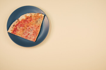 Wall Mural - Plate with a slice of pizza isolated on a bei background- free space for text