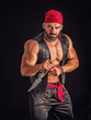 Muscular male pirate in studio shot, wearing bandana and open vest