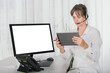 © JeanPaul - Shocked woman with headset in the office using digital tablet and computer screen is blank for copy space