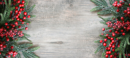 Wall Mural - festive winter christmas and new year holiday evergreen branches and red berries frame on sides over