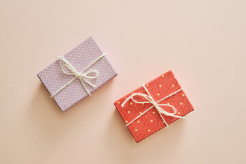 Sticker - Two gift boxes wrapped in color purple and red polka dots paper on pink background.