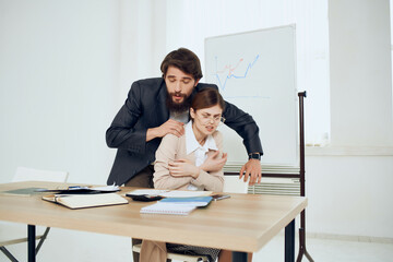 Wall Mural - a man harasses a woman at work here harassment office work colleagues