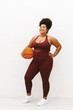 Confident fitness woman with basket ball