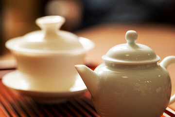 Poster - Porcelain cup and kettle on bamboo board