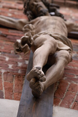 Wall Mural - Crucifixion of Jesus Christ. An ancient statue. Selective focus on feet. Faith, religion, death, resurrection concept.