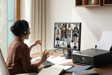 Wall Mural - smiling indian woman sit at desk at home office talk speak on video call with multiethnic diverse co
