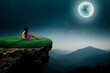 © Tongsai Tongjan - The little girl sat happily at the vantage point looking at the full moon at night.