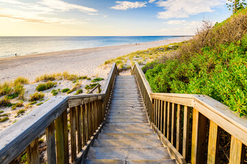 Wall Mural - Boardwalk to O'Sullivan Beach with people at sunset during a warm summer evening, South Australia