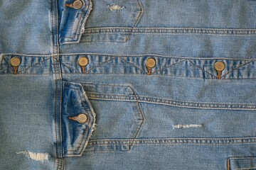 Wall Mural - a large part of a buttoned blue and worn denim jacket close-up