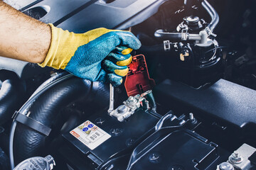 The Mechanic hand is fasten the bolt of battery Anode with the open-end wrench