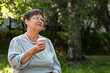 © Zuev Ali - Grandmother drinks coffee from a glass in a summer park.