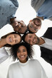 © fizkes - Close up vertical low angle portrait of smiling multiethnic diverse employees pose together look at camera laughing. Happy young multiracial workers friends have fun show unity. Diversity concept.