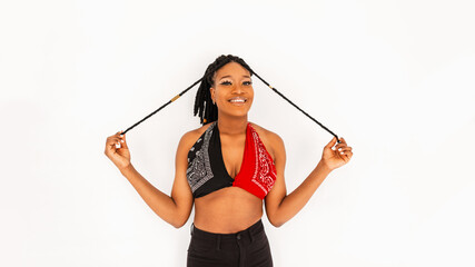 Wall Mural - Positive young African woman with joyful smile in trendy red-black bandana top posing on white background in studio. Cute smiling african american girl model wearing swag clothes. Modern fashion.