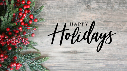 Wall Mural - happy holidays script text with holiday evergreen branches and red berries on side over rustic wood 