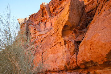 the mountain cliffs of the canyon are red against the blue sky