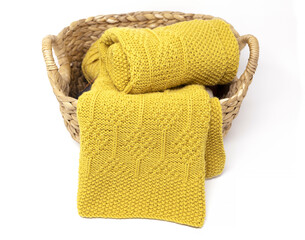 Wall Mural - Yellow knitted blanket in diamonds pattern in basket on white background