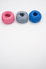 Poster - Closeup shot of soft colorful textile balls of wool on a white background with a copy space