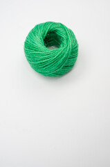 Canvas Print - Top view of a single soft green textile ball of wool on a white background with a copy space