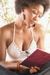 © Tetra Images - Young woman in crocheted top writing in journal